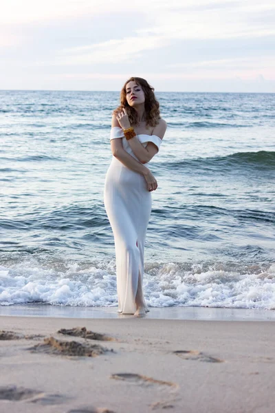 Rusya, Kalininingrad bölgesi, Baltık Denizi 'nde dar beyaz bir elbise içinde. Gece elbiseli kız, sudan seksi çıkıyor, adada düğün..