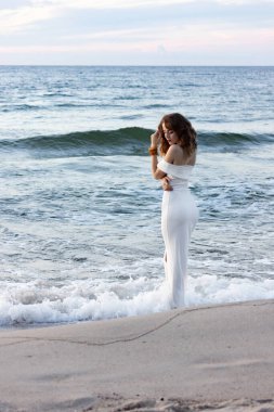 Rusya, Kalininingrad bölgesi, Baltık Denizi 'nde dar beyaz bir elbise içinde. Gece elbiseli kız, sudan seksi çıkıyor, adada düğün..