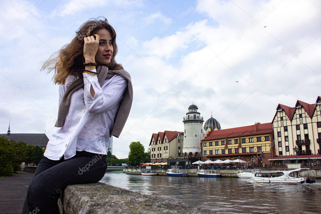 Russia, Kaliningrad region, Fishing village. Girl tourist posing against the background of others. Journey