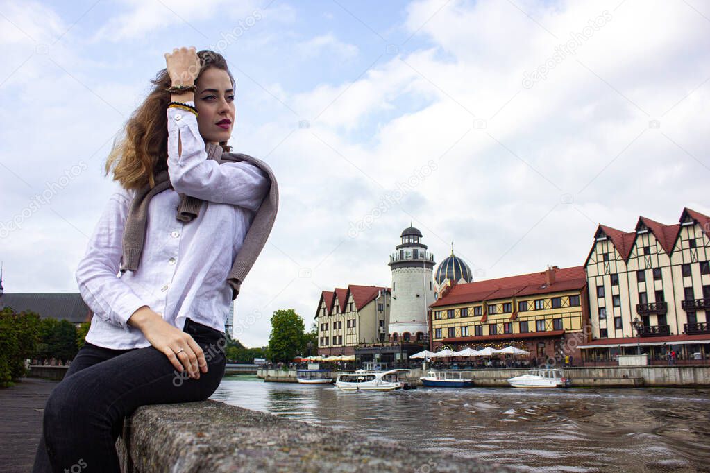 Russia, Kaliningrad region, Fishing village. Girl tourist posing against the background of others. Journey