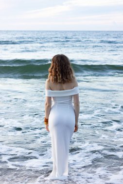 Rusya, Kalininingrad bölgesi, Baltık Denizi 'nde dar beyaz bir elbise içinde. Gece elbiseli kız, sudan seksi çıkıyor, adada düğün..