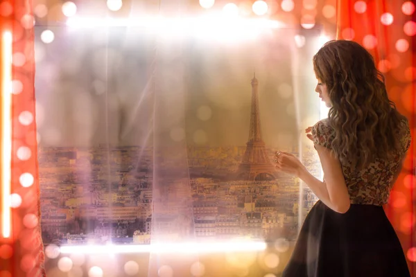 stock image A girl stands near the window overlooking Paris and dreams.