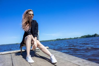 Çirkin su deposu Kalyazin şehrinin arka planında siyah ceketli bir kız. Kaya kıyısı.