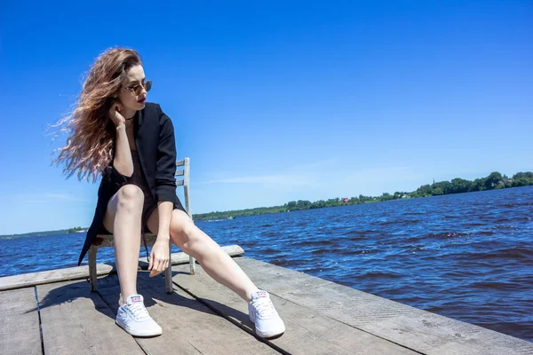 Una Niña Con Una Chaqueta Negra Sobre Fondo Del Embalse —  Fotos de Stock