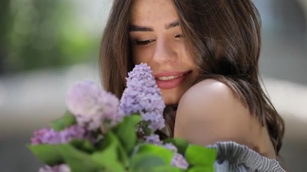 Счастливая женщина наслаждается свежим лиловым запахом вблизи — стоковое видео