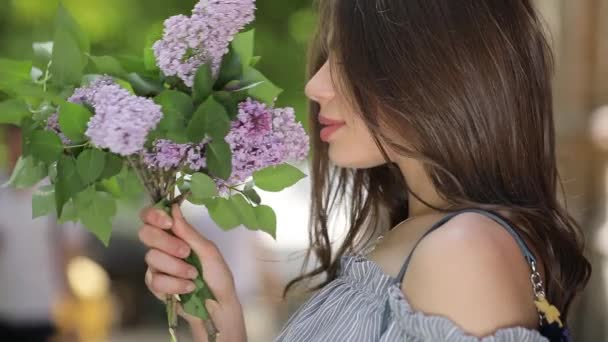 Mujer feliz disfrutando de fresco olor a lila — Vídeo de stock
