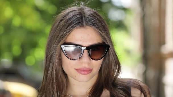 Красивая женщина в солнечных очках целуется — стоковое видео