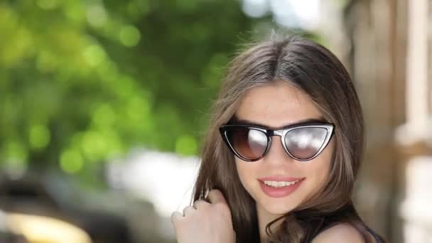 Ganska kokett kvinna i solglasögon gör antenn kyss — Stockvideo