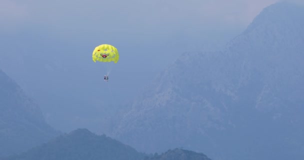 Bir deniz, gök, dağ arka plan sarı paraşüt paraşüt — Stok video