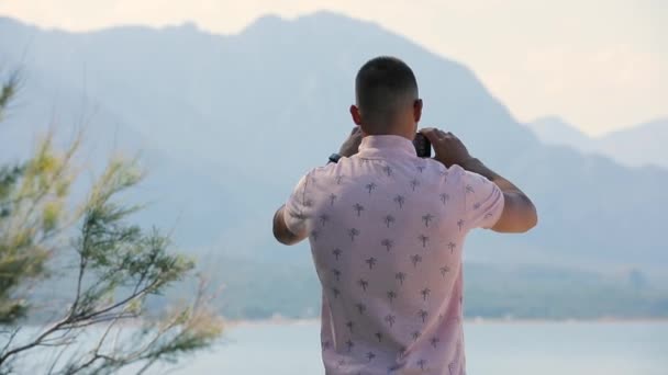 Joven hacer foto panorámica o vídeo de las montañas del mar con el teléfono inteligente — Vídeos de Stock