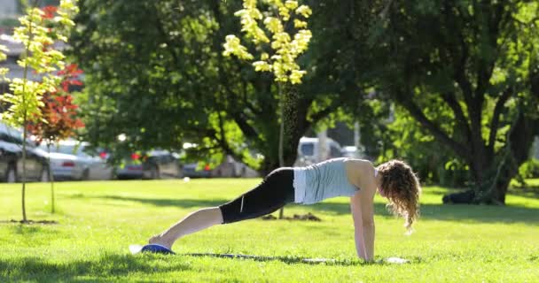 Jonge vrouw uitoefening van yoga in park, gezonde levensstijl concept — Stockvideo