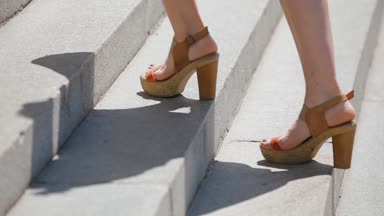 Merdivenlerde Topuklu sandaletler içinde kadın bacakları yukarı