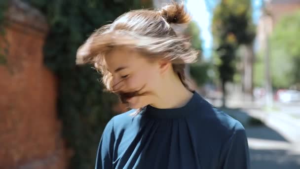 Улыбающаяся милая счастливая девушка бросает свои волосы в летний день — стоковое видео