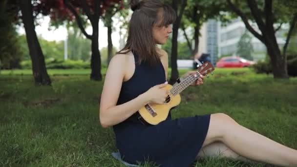 Jovem mulher jogar no ukulele, guitarra pouco — Vídeo de Stock