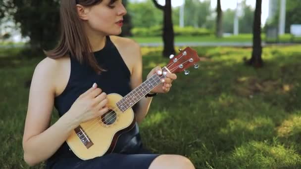 Young woman play on ukulele, little guitar — Stock Video