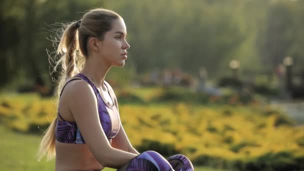 Sportig kvinna avkopplande på naturen sitter på gräset, andas frisk luft — Stockvideo