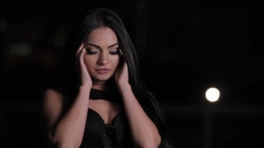 Esmer kadın saç ile oynarken oldukça ve bir gece şehirde dokunma