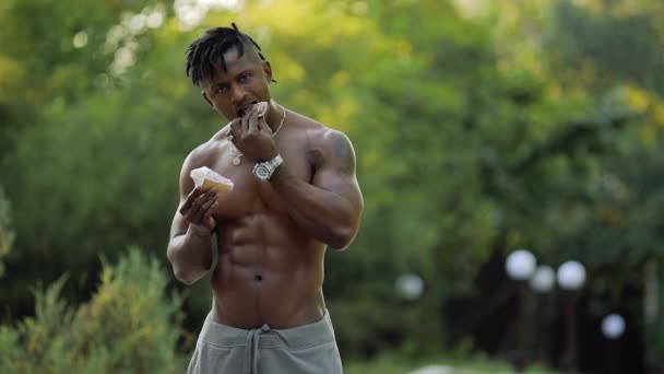 Africano macho hombre topless comer helado — Vídeo de stock