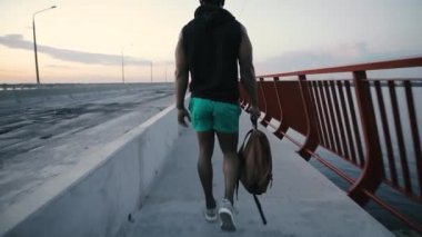 Yürüyen adam ve düşünme akşam, köprüdeki ihale, arkadan görünüm