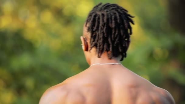 Muscular homem negro africano fisiculturista andando topless em um parque — Vídeo de Stock