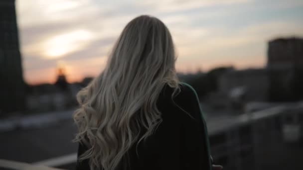 Relaxed girl looking forward at evening city roof — Stock Video