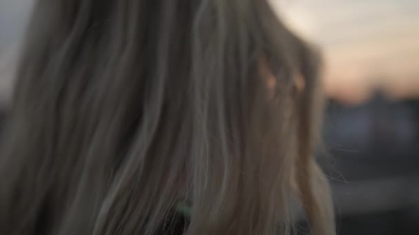 Relaxed girl looking forward at evening city roof, fresh air wind blowing hair — Stock Video