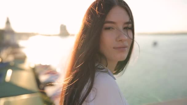 Молодая улыбающаяся женщина портрет в солнечном свете на мосту, замедленная съемка — стоковое видео