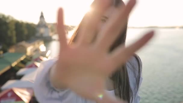 Молодая женщина веселится под солнцем на мосту, замедленная съемка — стоковое видео