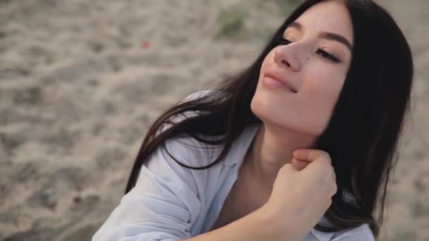 Nehir kumsalda oturma sevimli genç kadın portre — Stok video