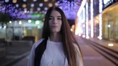 Şehir merkezinde müzik ve rahatlatıcı gece city adlı yürüyen yalnızlık kadın