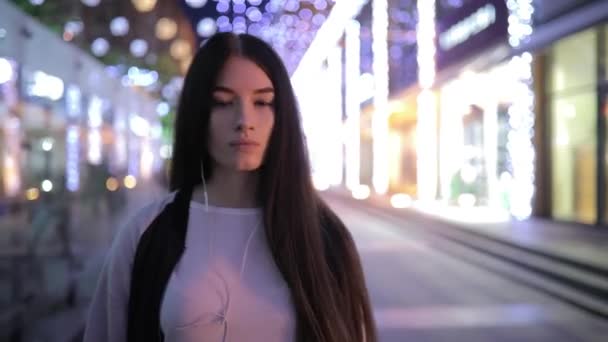 Mujer solitaria caminando por la noche ciudad centro escuchando música y relajándose — Vídeos de Stock