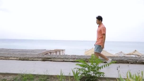 Человек акробат сделать обратный сальто на морской набережной — стоковое видео