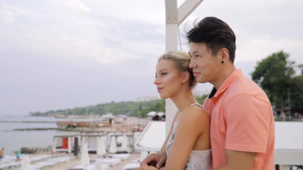 Young couple looking at the sea, girl shows her something interesting — Stock Video