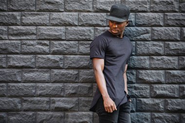 Afro-Amerikan yakışıklı boş siyah t-shirt ayakta duvara karşı