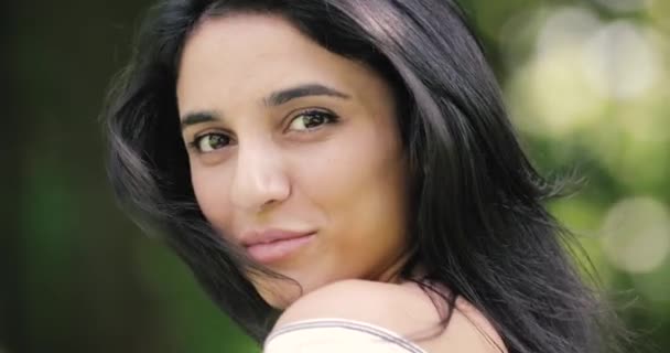 Vonzó fiatal nő ül a parkban, szépség arc jelent — Stock videók