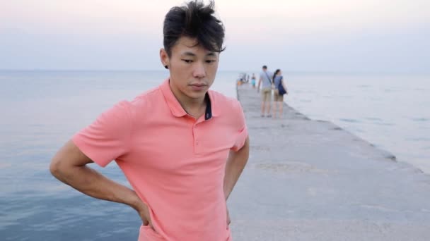 Dramatische portret van man kijken camera staande op zee pier — Stockvideo