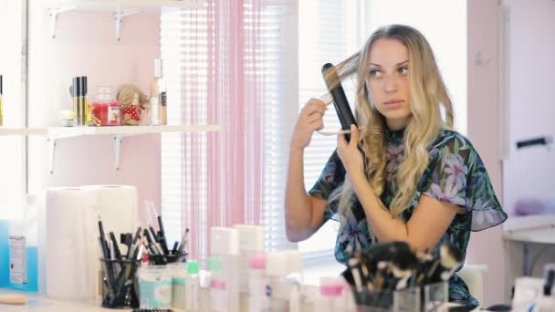 Vrouw krullen haar haren met een toverstok curling — Stockvideo