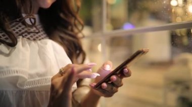 Kadın gece şehirde app kullanarak onun smartphone bakarak tarama