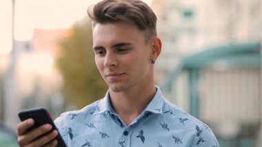 Smartphone closeup app isteyen genç gülümseyen adam