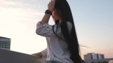 Bakımlı kadın güzel saçlarını çatıda günbatımı zamanında dokunmadan