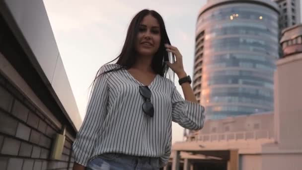 Mujer joven vuelta atrás y mirando al edificio de la ciudad alta — Vídeos de Stock