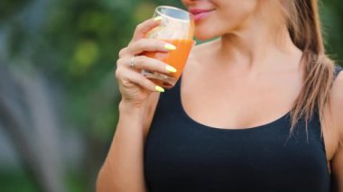 Yetişkin kadın bir bahçe, sağlıklı bir yaşam tarzı kavram portakal suyu içme