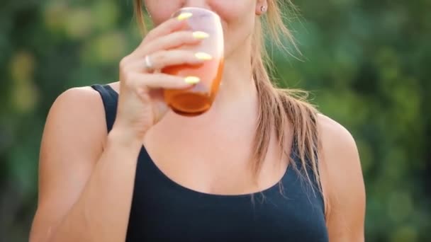 Donna adulta che beve succo d'arancia in un giardino, concetto di stile di vita sano — Video Stock