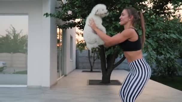 Доросла жінка займається з собакою на відкритому повітрі — стокове відео