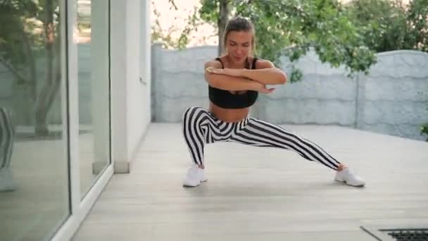 Femeia adultă care face exerciții în aer liber lângă casa ei — Videoclip de stoc