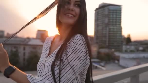 Досить привабливий портрет молодої жінки на даху під час заходу сонця — стокове відео