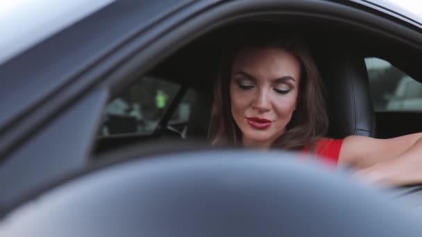 Mujer sexy conductor sentado en el salón de coches mirando en ventana abierta — Vídeo de stock