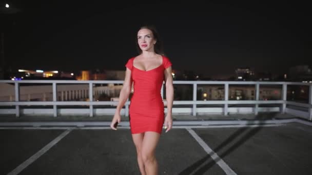 섹시 한 빨간 드레스에 여자 밤 도시에서 그녀의 차에가 서 — 비디오