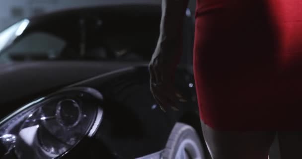 Mujer en vestido rojo sexy tocar su coche en la ciudad de la noche — Vídeo de stock