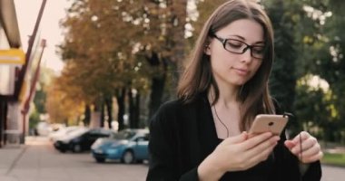 Müzik veya sesli kitap sonbahar şehirde yürüyüş sırasında dinleme kadın